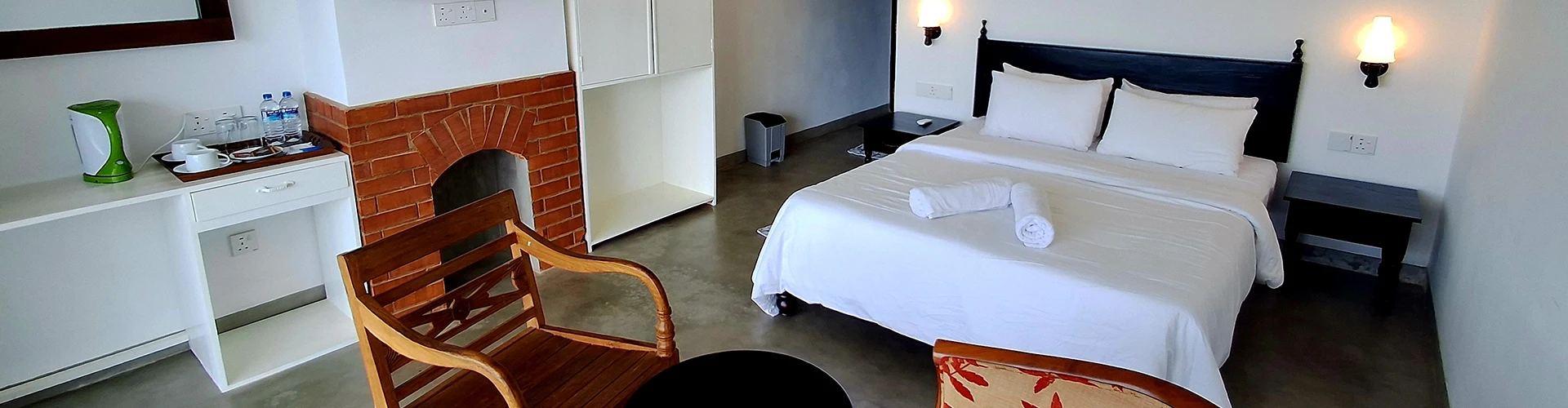 A comfortable bedroom with a well-made bed, a cozy chair, and a flat-screen television
