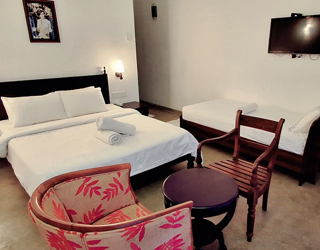 A comfortable bedroom with a well-made bed, a cozy chair, and a flat-screen television